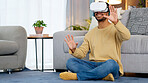 Male gamer using a VR headset to access the metaverse while gaming online at home. Young man enjoying video games with wireless headphones while entering an immersive 3D virtual reality experience