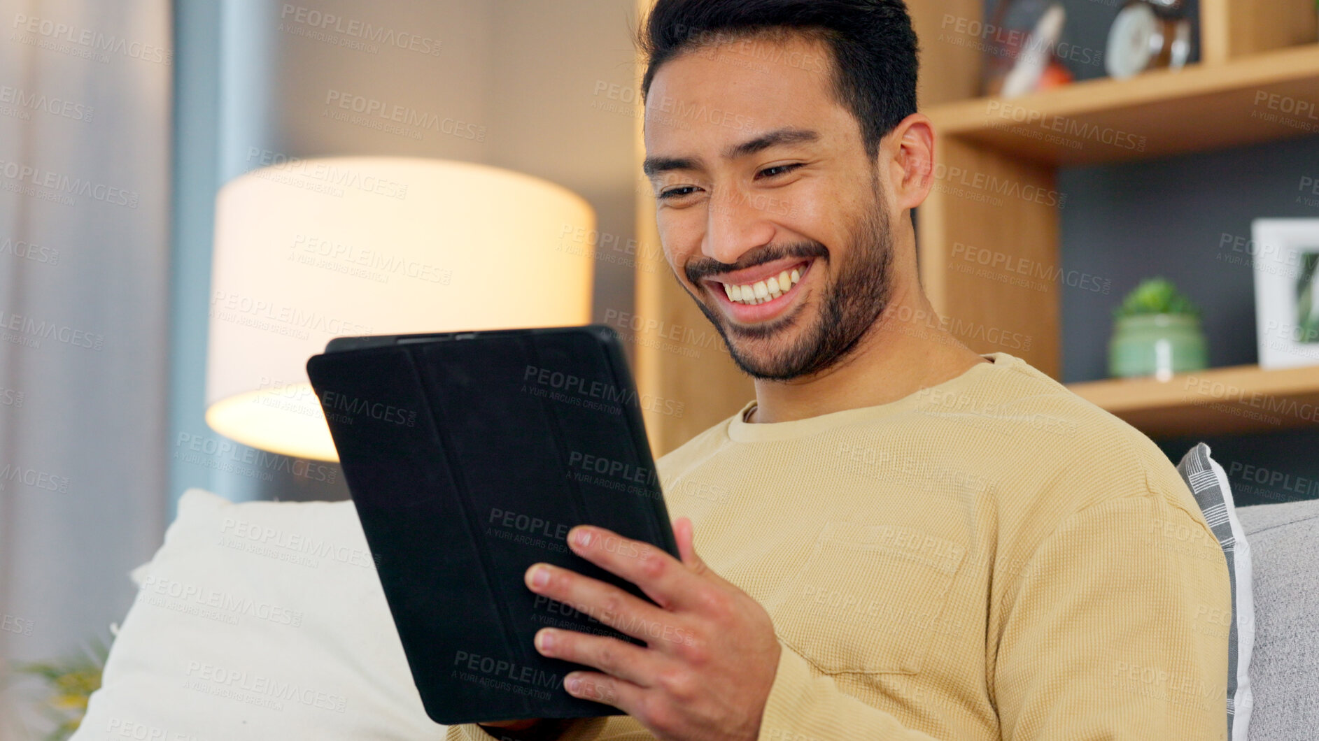 Buy stock photo Laugh, relax and asian man with a tablet a sofa for social media, chat or streaming at home. Digital, app and Japanese male in a living room smile for gif, meme or web, post and online communication