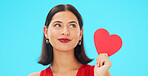 Face, smile and woman with red heart, emoji and romantic support against a blue studio background. Portrait, female or confident person with symbol for love, flirty and passion for romance and loving