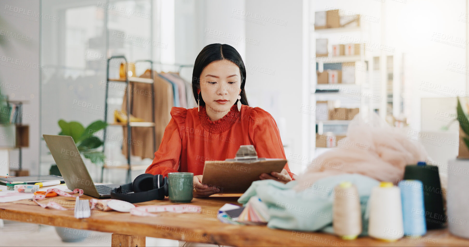 Buy stock photo Fashion designer woman planning her small business startup with checklist in textile, tailor and fabric check at office studio. Quality control, manufacturing and asian person coffee for productivity