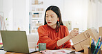 Box, ecommerce and laptop with asian woman writing for order, delivery and online shopping distribution. Seller, package and retail with small business owner for parcel, shipping and labelling