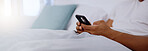 Typing, bed and hands of a man with a phone for social media, communication and chat. Contact, internet and guy scrolling on a mobile app for messages, reading emails or notification in the bedroom