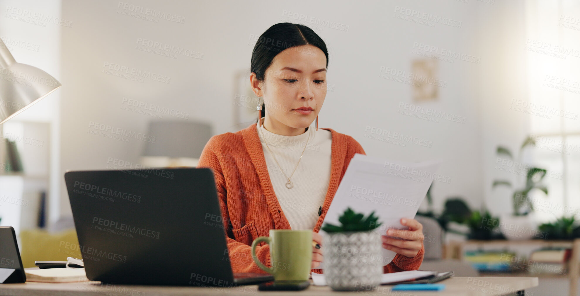 Buy stock photo Remote work, paperwork and Asian businesswoman working on laptop from home, house or apartment. Freelance, worker and professional employee review report and planning company strategy on documents