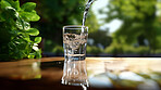 Close up of pouring purified water in glass. Fresh spring mineral water for hydration.