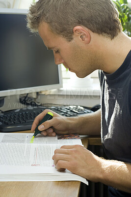 Buy stock photo Cropped shot of a young man highlighting important study notes