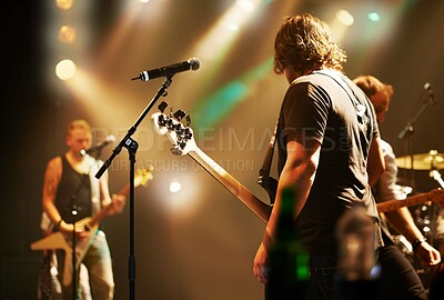 Buy stock photo Performance, musician and men in a band at a concert for a music festival, event or show together. Night, stage and a group of people performing, singing and playing instruments at a club for a party