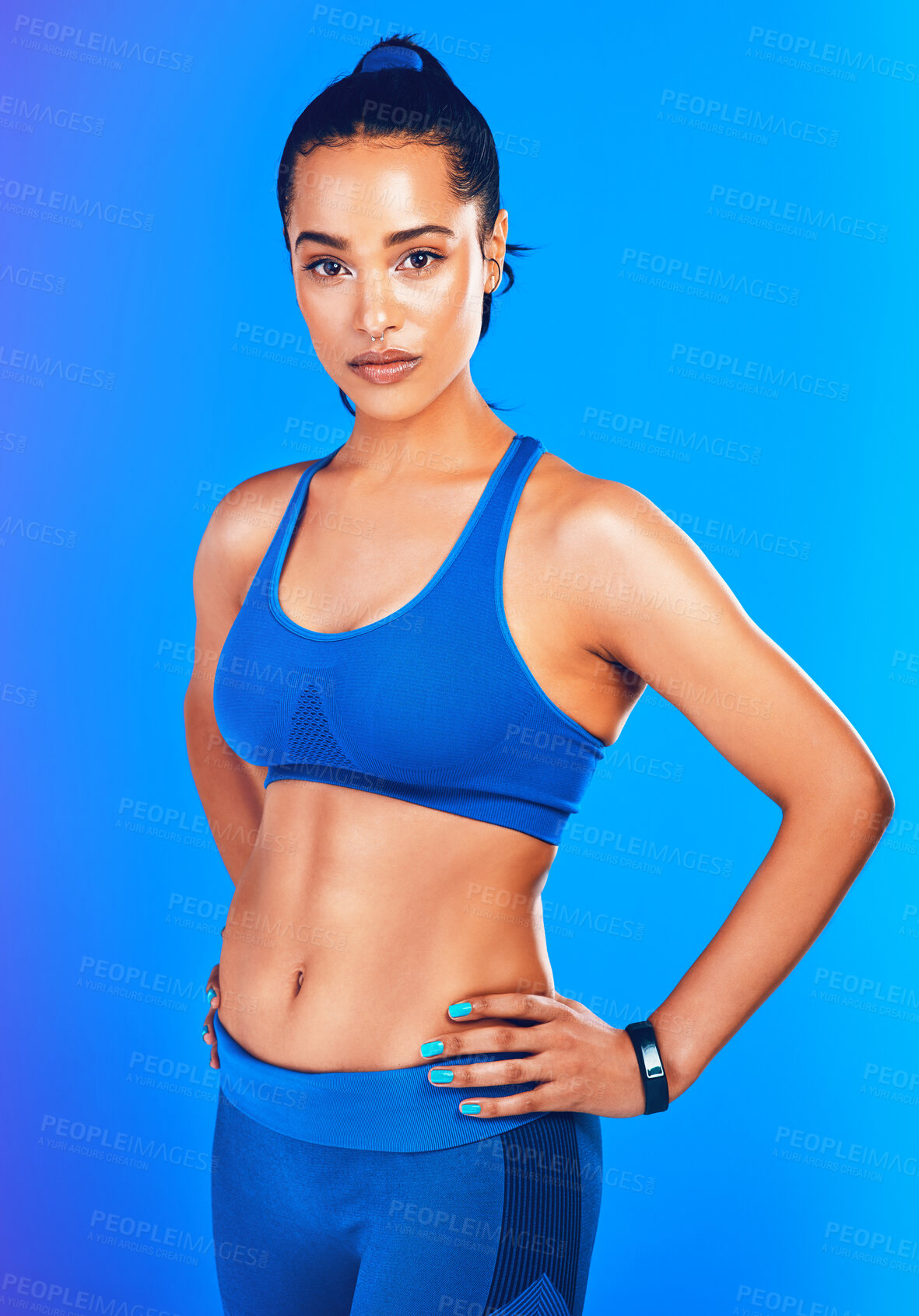 Buy stock photo Studio portrait of an attractive young sportswoman posing against a blue background