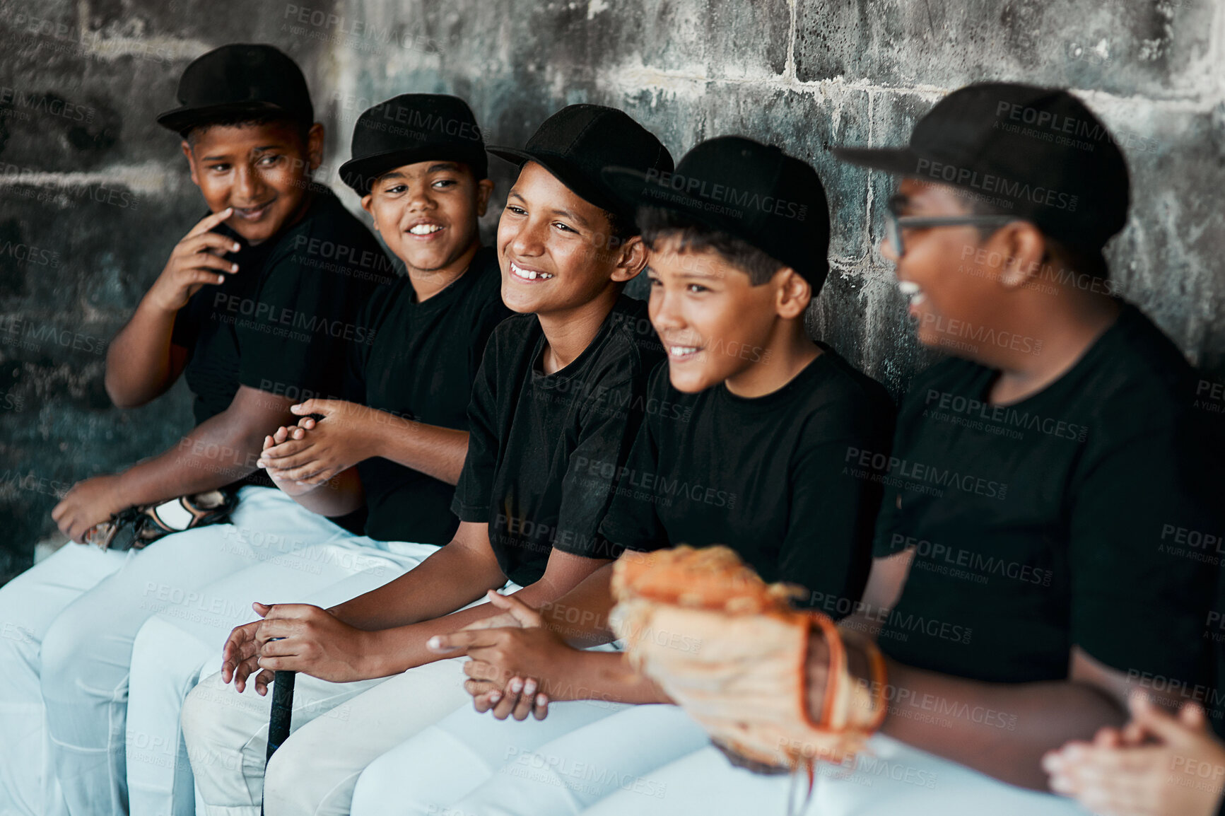 Buy stock photo Cropped shot of a group of young baseball players sitting together on the bench during a game
