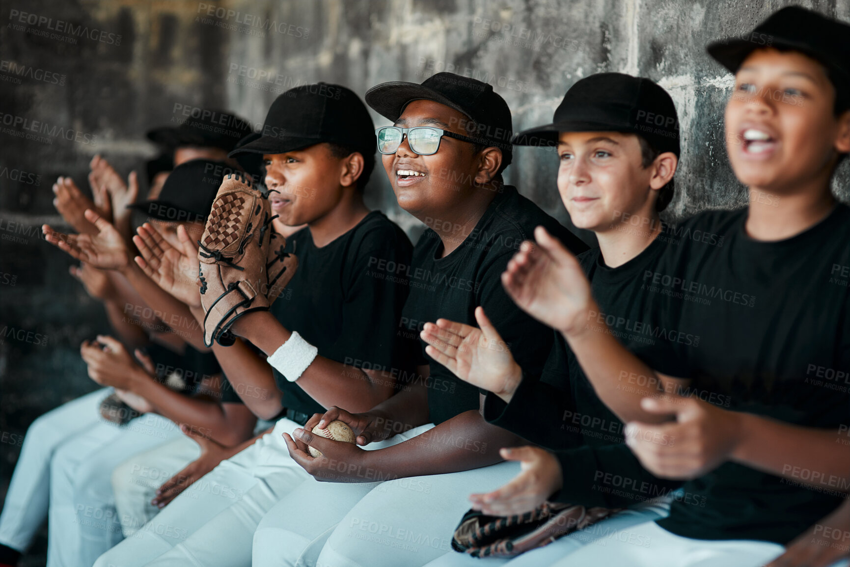 Buy stock photo Cropped shot of a group of young baseball players cheering and supporting their team from the bench during a game