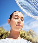 Tennis racket, face and shadow on sports woman with motivation, wellness goals and winner mindset. Portrait of fitness person on court for exercise, workout and training for professional competition