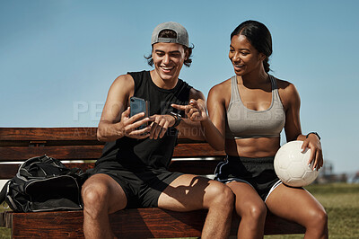 Buy stock photo Sports friends, phone and relax while sitting in a park together, bond and laughing at social media post before morning cardio. Fitness, couple and online entertainment on park bench after training 