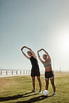 Fitness, beach park and couple doing a stretching exercise as a warm up for football training. Sports, athletes and healthy man and woman doing workout for health, wellness and motivation for soccer.