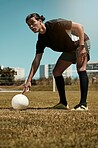 Man, placing and soccer ball on with hand on field for kick, penalty or goal in game, training or match. Sport, football and grass in summer for exercise, fitness and workout in sports for wellness