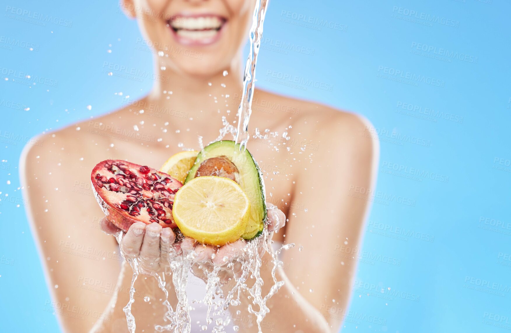 Buy stock photo Cleaning, water and hands with fruit in studio on blue background for nutrition, natural and healthy lifestyle. Wellness, body care and woman with fruits and vegetables with water splash for diet