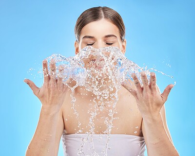 Buy stock photo water splash, woman and face skincare cleaning for beauty healthcare or natural skin wellness in studio. Young model, facial glow and healthy dermatology or self care hygiene in blue background