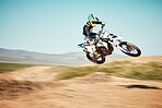 Motorcross, air jump and offroad sports with motion blur, speed challenge or desert. Driver, cycling and stunt on dirt track, competition and motorbike performance on adventure course for fast action