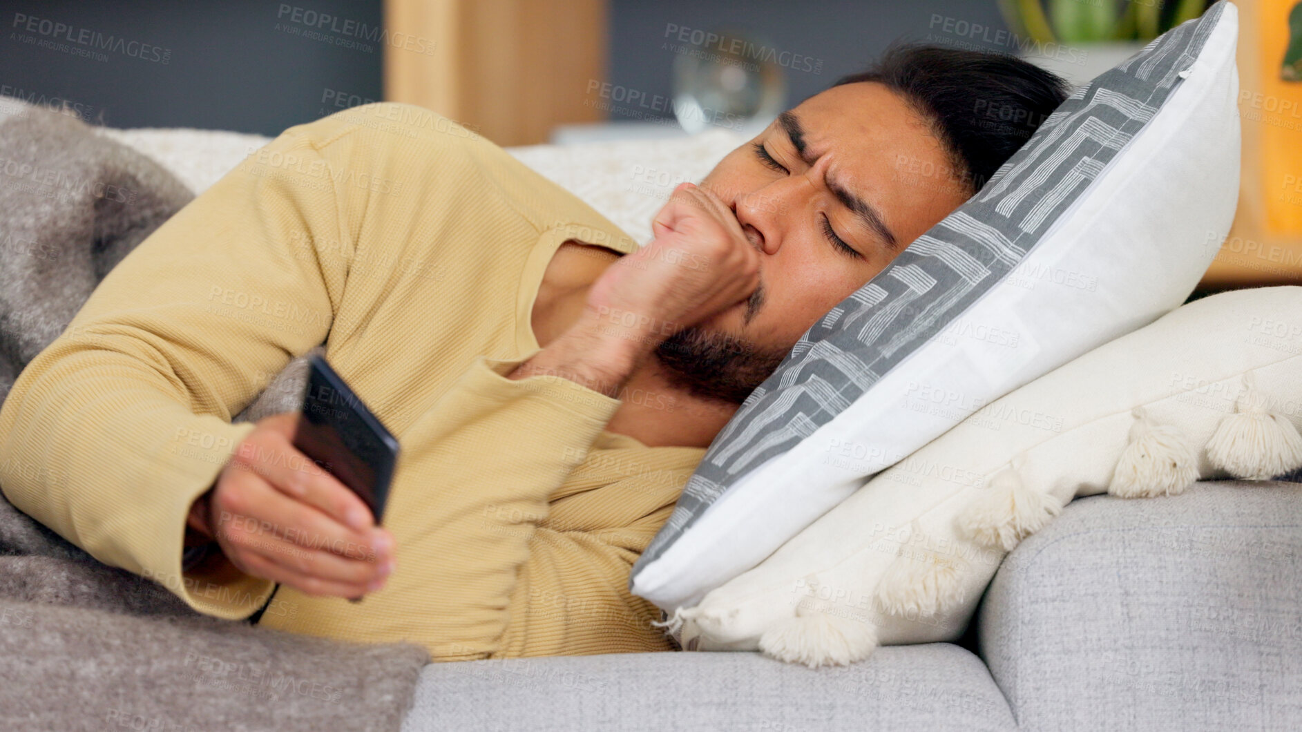 Buy stock photo Man, phone and cough on sofa in home living room, texting or communication with email notification. Guy, smartphone and sick with research for health, medicine or watch video on social media in house