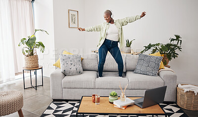 Buy stock photo Dance, black woman and listening to music on the sofa for freedom, the radio or an audio. House, streaming or African girl with headphones for a podcast, playlist or enjoying a song on the couch