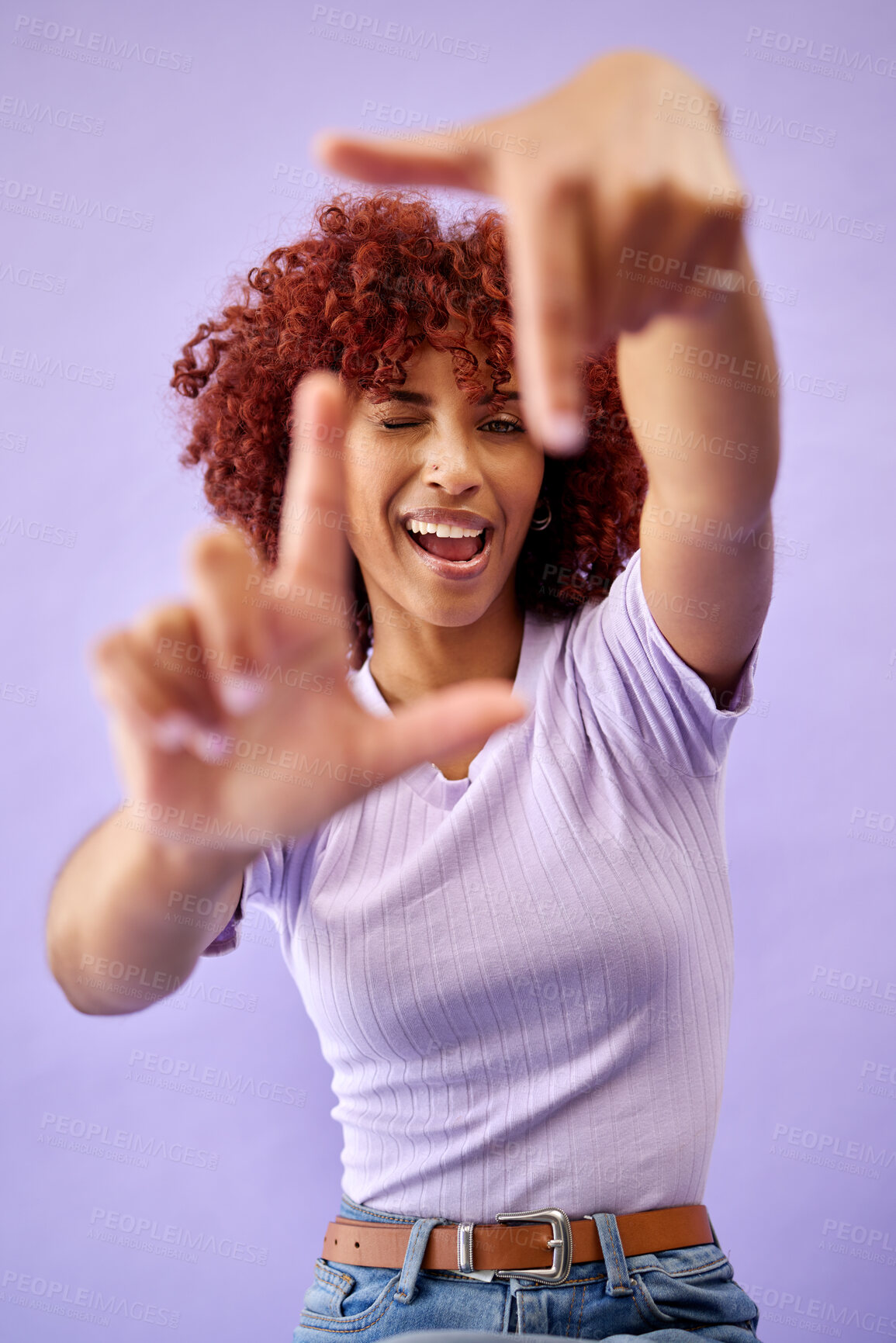 Buy stock photo Portrait, hands frame and happy woman wink in studio isolated on a purple background. Face, finger border and person excited for photographer selfie, profile picture and smile in creative perspective