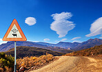 Desert, sign and alien abduction in the mountains with a ufo warning along a dirt road on a blue sky. Nature, summer and and a route into area 51 with extraterrestrial signage on an empty landscape