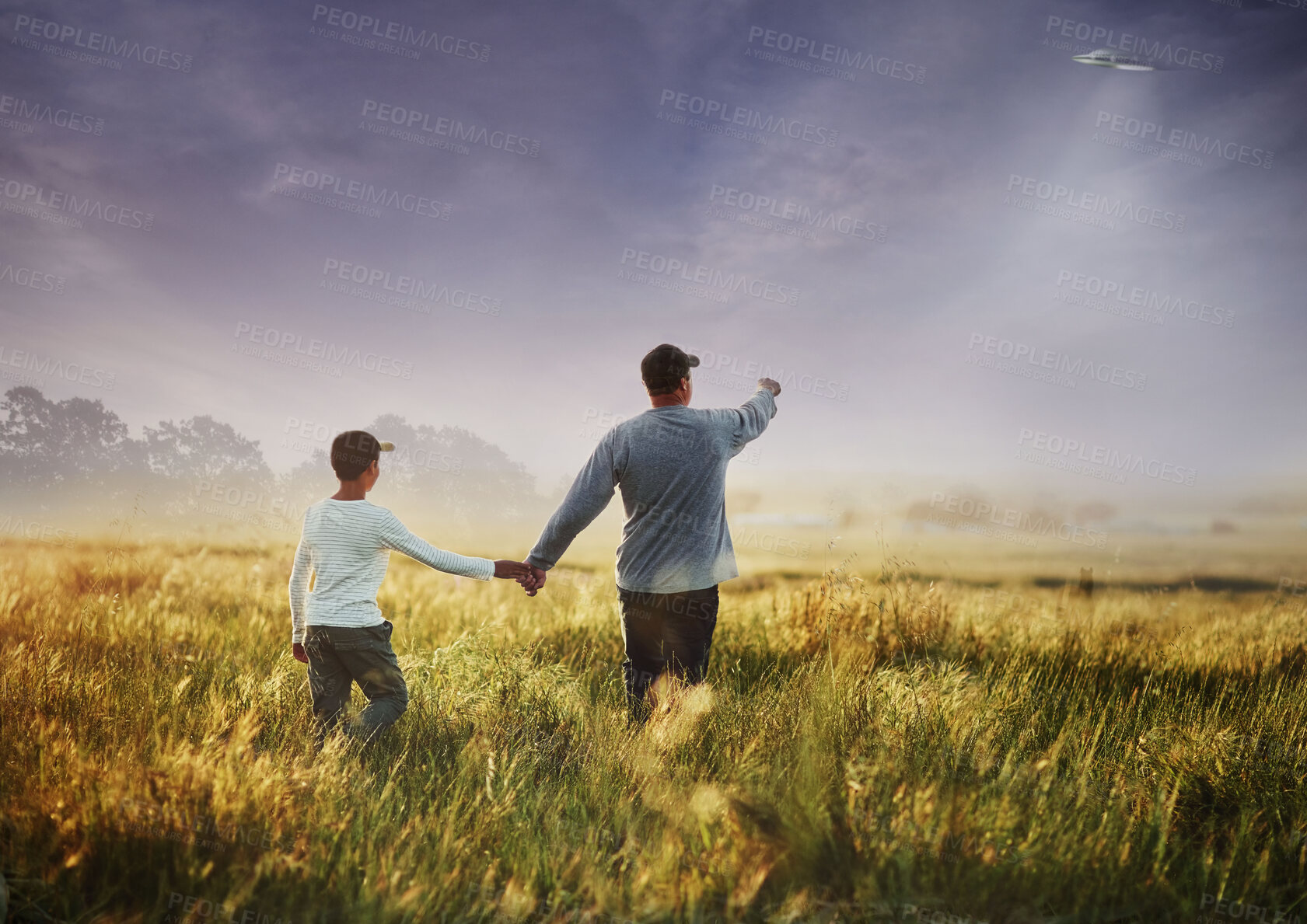 Buy stock photo Back, alien and flying spaceship with a family outdoor in nature together during invasion or ufo discovery. Universe, earth and people in the countryside to search for proof of extraterrestrial life