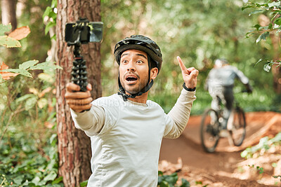 Cycling man, selfie and happy in forest, pointing and excited for wellness, training or blog on adventure. Influencer guy, helmet and smile in profile picture, memory or live stream on social network