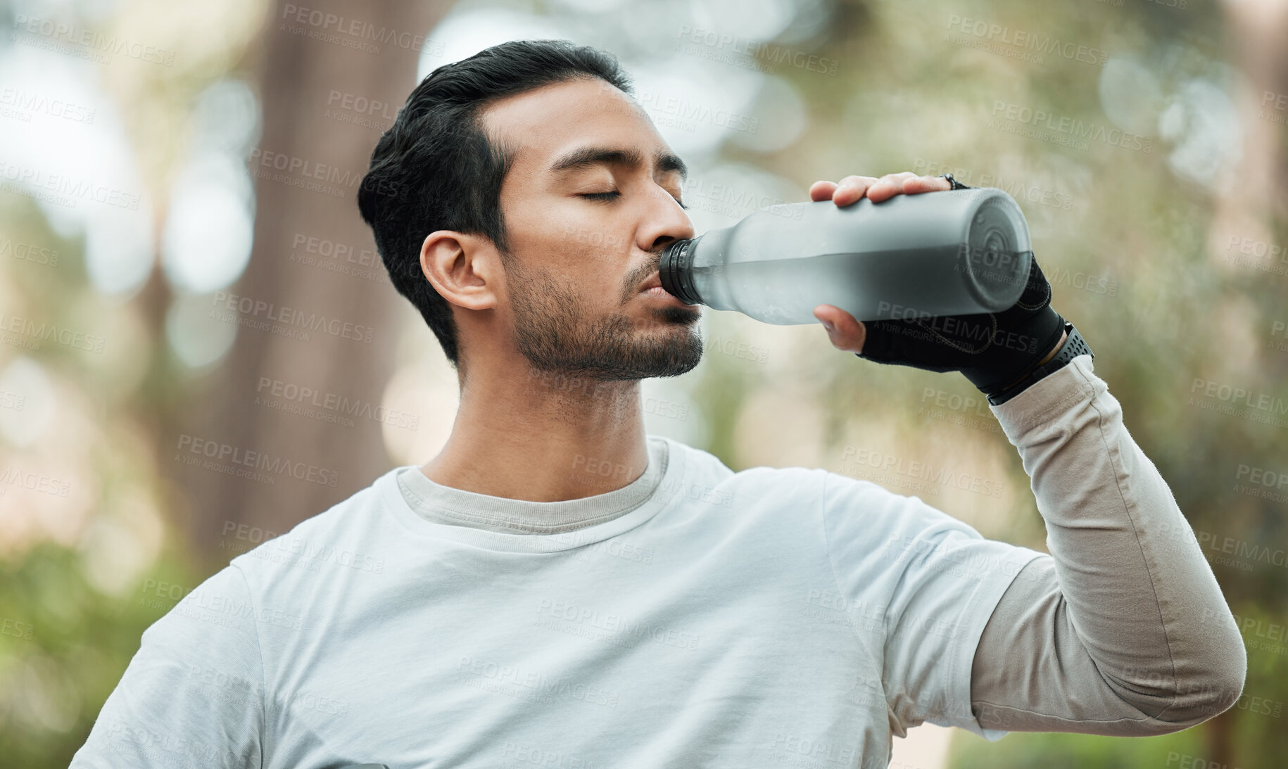 Buy stock photo Sports, man and drinking water in park for exercise break, energy and workout rest. Thirsty athlete, asian runner and bottle for hydration, nutrition and healthy recovery of fitness in nature outdoor