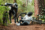 Men, legs and injury in forest with bike, helping and talk for care, advice and motivation on ground in nature. Cycling friends, emergency or accident with bicycle, training and knee pain in woods