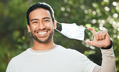 Buy stock photo Portrait, mask and remove with a man breathing fresh air in nature, feeling happy at the end of restrictions. Covid, freedom and smile for post lockdown with a young person in the forest or woods