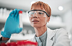 Woman, scientist and blood sample in lab, thinking and analysis with ppe glasses, safety and test. Science, pathology and expert with ideas, inspection or check for medical research in laboratory