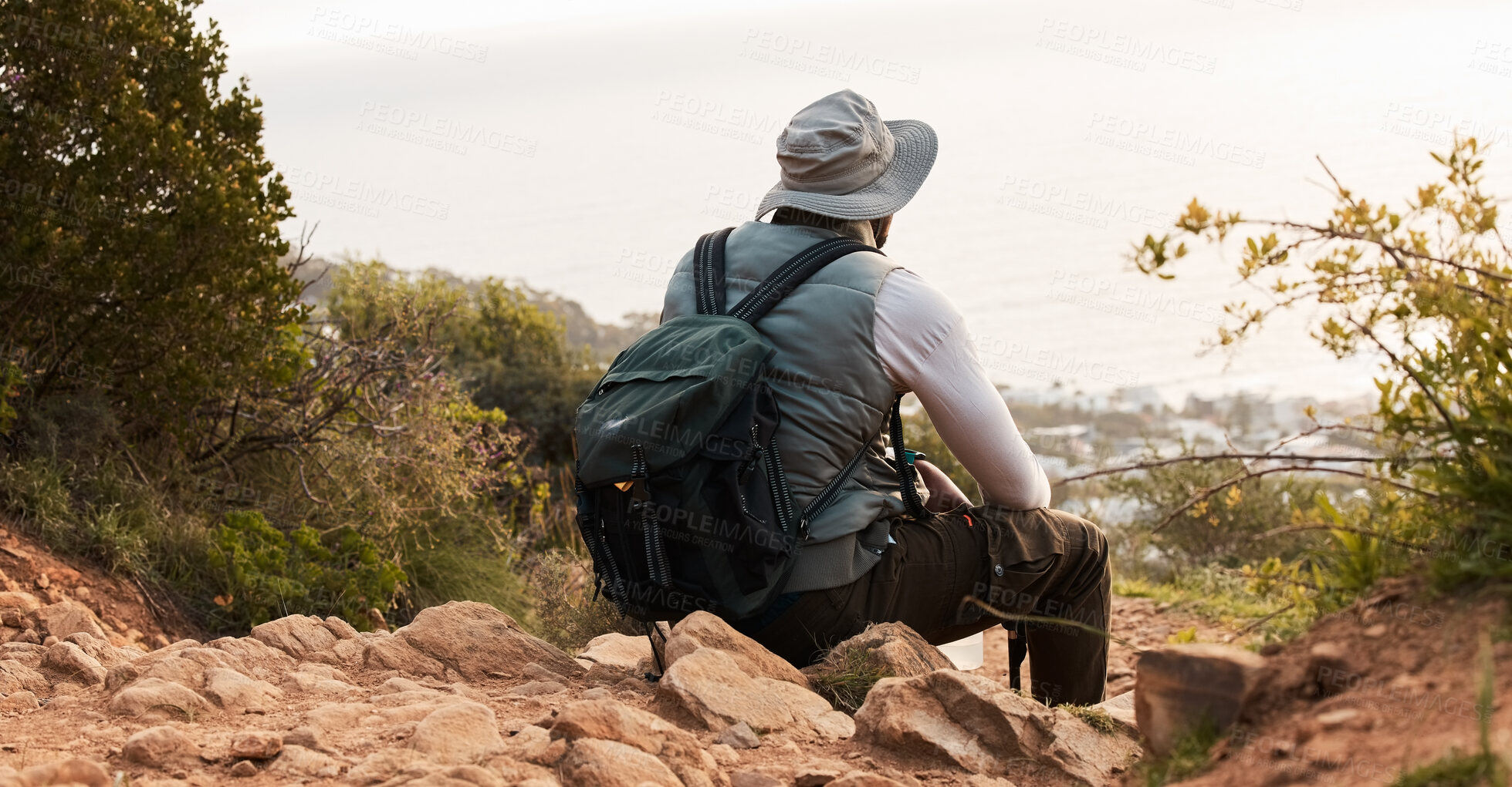 Buy stock photo Back, relax and view with a black man hiking in the mountains for travel, freedom or adventure in a remote location. Hike, break and scenic with a backpacker or hiker outdoor in nature to explore