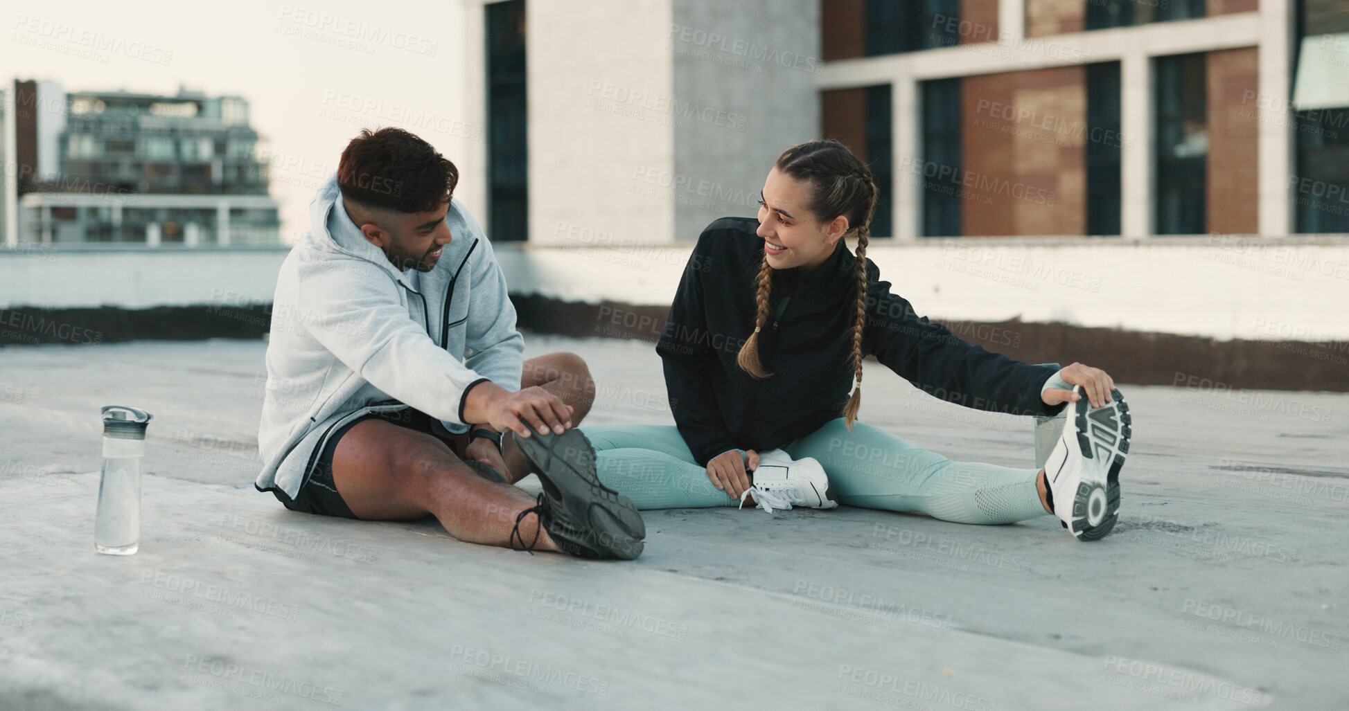 Buy stock photo Fitness, couple and stretching body on rooftop in workout, exercise or outdoor training together. Happy man and woman in warm up or getting ready for cardio, practice or sports preparation in city