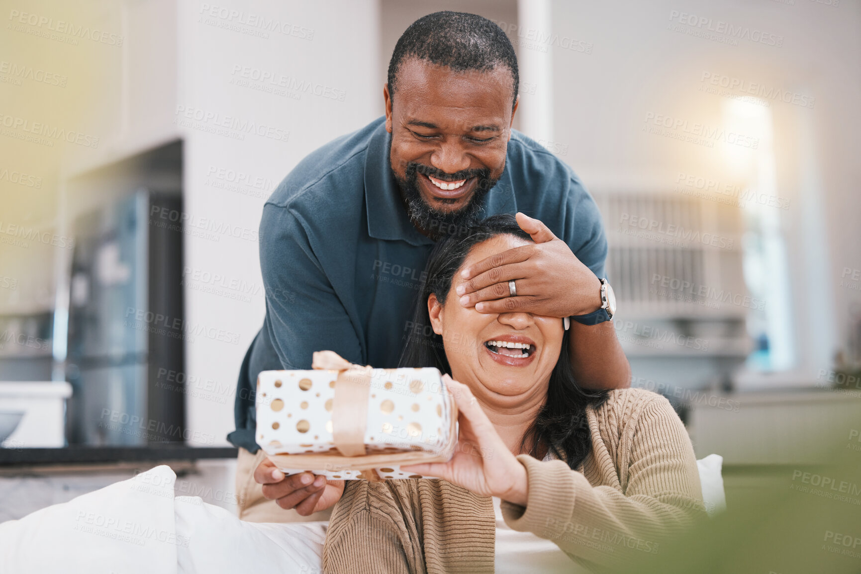 Buy stock photo Birthday gift surprise, cover eyes and couple smile, woman and black man giving package for love, anniversary or gratitude. Living room couch, marriage and home people happy for present box