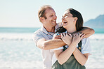 Happy, couple and hug by the sea with love, laughing and bonding on vacation at ocean. Summer, romance and people together for holiday by the beach in Bali with adventure and journey on honeymoon