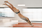 Swimming, pool and sports man dive into liquid water, cardio training or fast competition, triathlon practice or action. Speed blur, air and swimmer workout, fitness or training for race competition