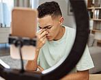Headache, live streaming and man with stress, fear and tired of social media and sad for cyberbullying online in home. Problem, worry and frustrated person or influencer on internet, web or blog