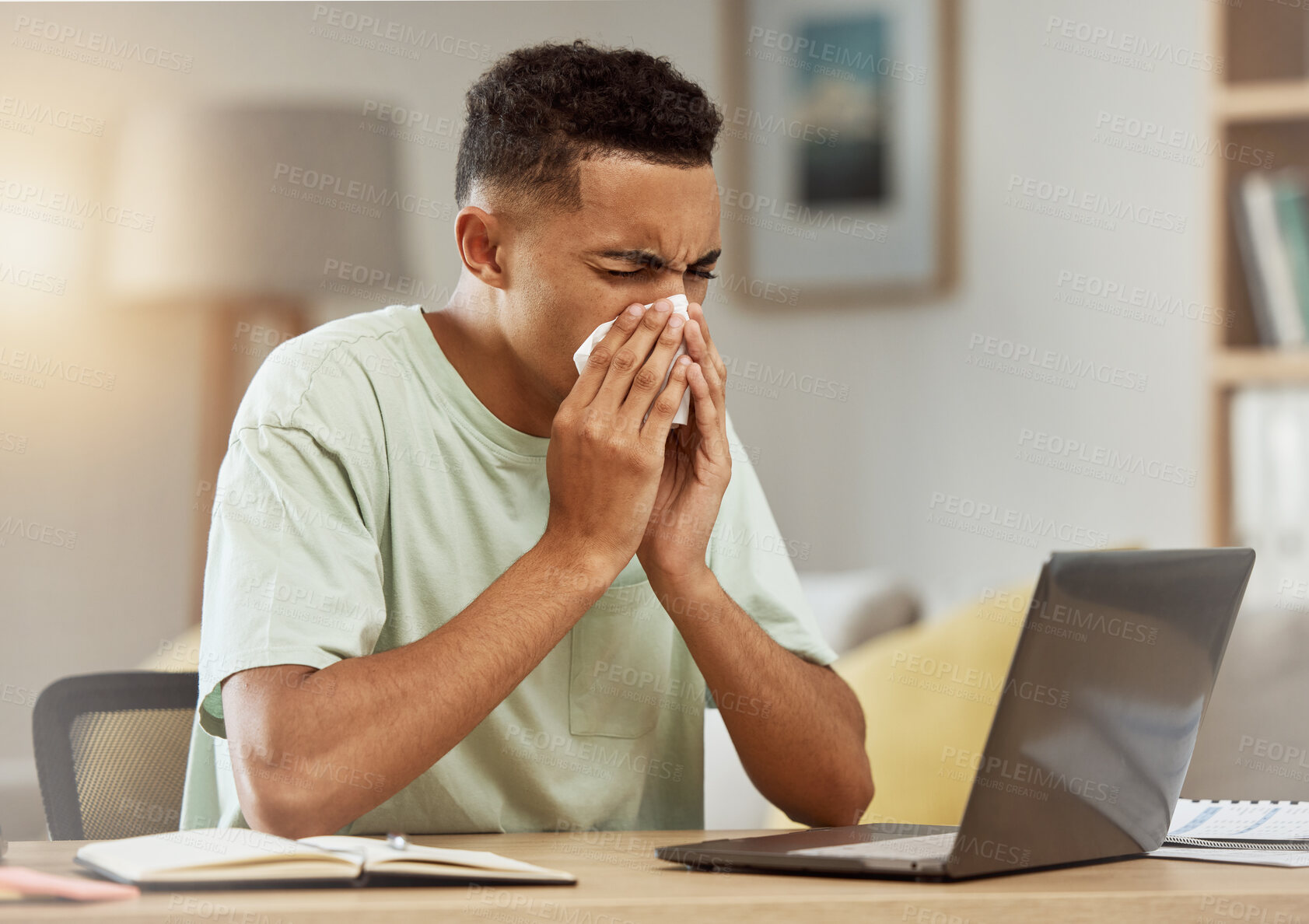 Buy stock photo Sneeze, man and tissue in living room with flu, virus or cough while learning online at home. Health, person and fever blow nose with tissue from influenza, illness or cold by table in apartment