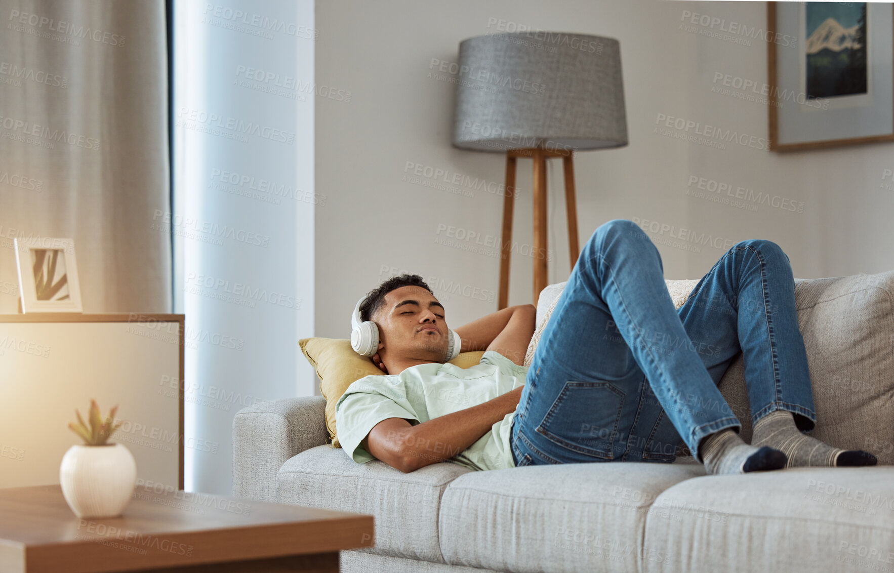 Buy stock photo Man on sofa with headphones, relax and sleep in living room with chill sound, streaming or podcast meditation. Zen, music and person on couch with earphones, peace and calm audio for wellness in home