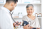 Stethoscope, blood pressure and doctor with mature woman in consultation at hospital or clinic. Healthcare, exam and patient with medical professional for check up for heart health, advice and care.