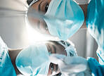 Low face, looking and doctors in surgery for healthcare, working or help in cardiology. Inspection, hospital and a nurse team or surgeon in theater for a medical procedure or operation or exam