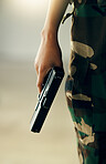 Hand, gun and a soldier closeup on the battlefield during war or combat training for the military. Army, warrior or hero and a person in camouflage uniform with a pistol, firearm or weapon for safety