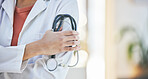 Woman, doctor and hands with stethoscope of professional in healthcare, cardiology or advice at hospital. Closeup of female person or medical expert with arms crossed, equipment or examination tool