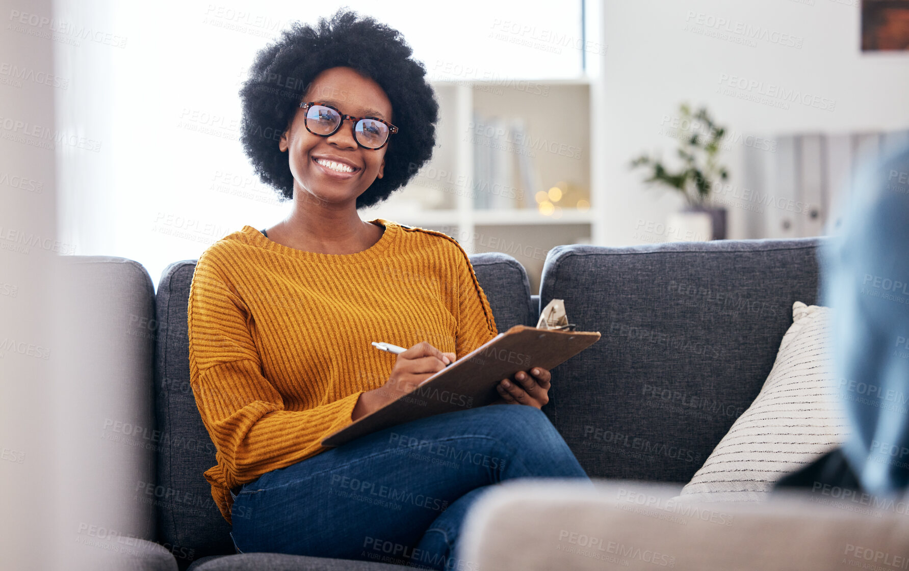 Buy stock photo Black woman therapist on sofa with notes, smile and patient for advice and psychology, listening and mental health care help. Conversation, support and psychologist on couch with client in counseling