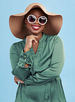 Fashion, sunglasses and portrait of black woman with smile for summer style isolated in a studio blue background. African, hat and young person travel with clothes for glamour  or luxury accessories