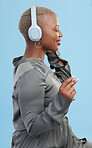Black woman, headphones and music, profile and technology with audio streaming isolated on blue background. Listening to radio, wireless tech for podcast and subscription with peace in studio