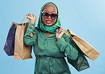 Black woman, portrait and shopping bags in fashion, style or sunglasses against a studio background. African female person shopper with scarf, gifts or groceries in stylish clothing, sale or discount