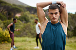 Stretching, fitness and portrait of a man outdoor for health and wellness. Serious runner, athlete or sports person in nature park to start exercise, workout or training with arm muscle warm up