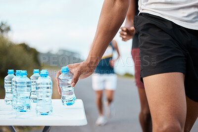 Hand, water and a marathon runner in a fitness competition or race closeup for cardio on a street. Sports, exercise or health with an athlete grabbing a drink while outdoor on the road for a run