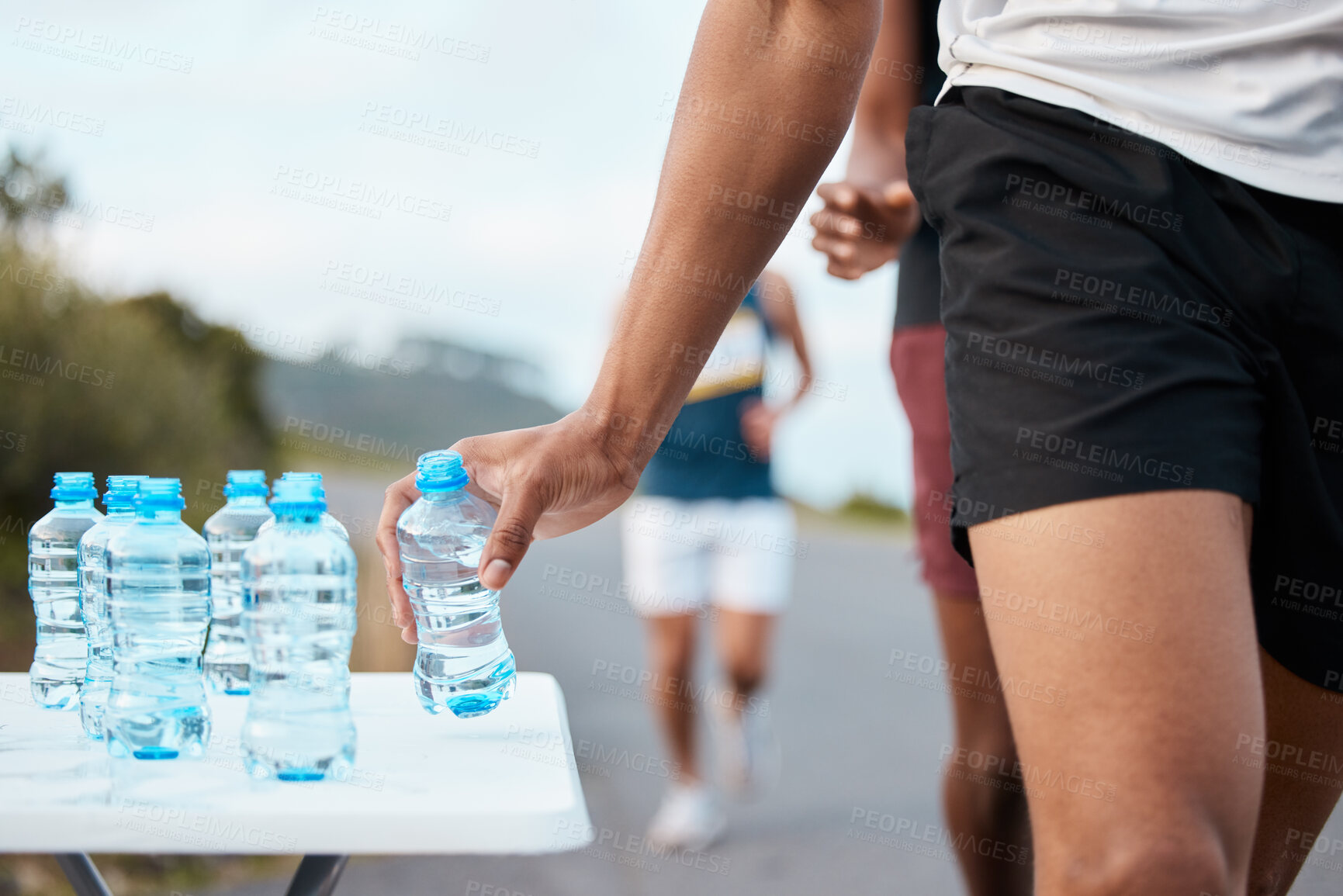 Buy stock photo Hand, water and a marathon runner in a fitness competition or race closeup for cardio on a street. Sports, exercise or health and an athlete person with a drink while outdoor on the road for a run