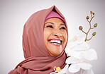 Smile, thinking and Muslim woman with flowers in studio isolated on white background. Happy Islamic model with floral plant for skincare, orchid for healthy skin or organic makeup for beauty cosmetic